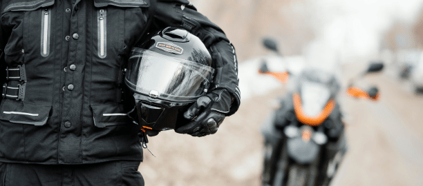 motorcycle rider holding helmet