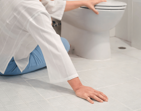 woman holding on to a toilet after a fall