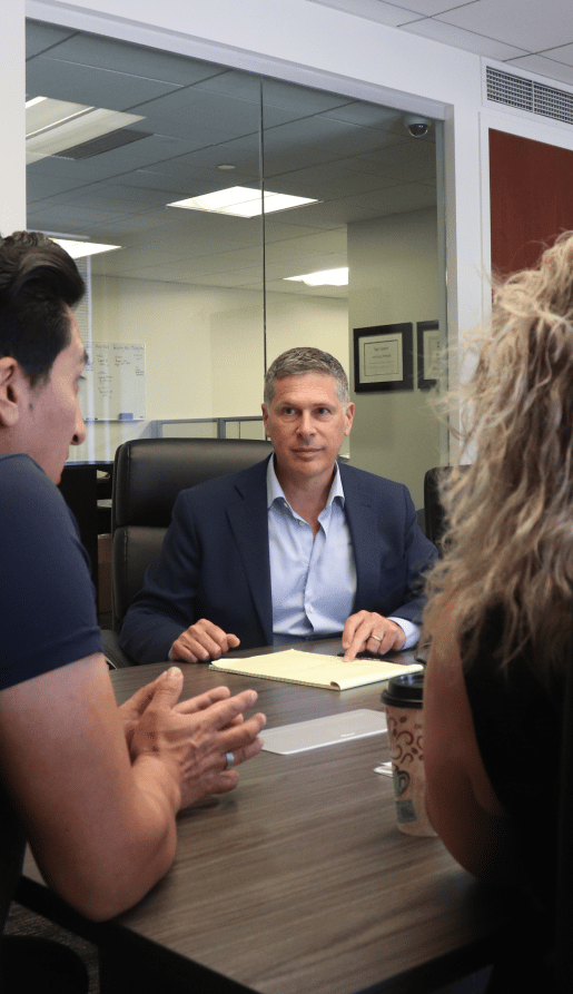 attorney Mitchell Proner talking to clients at a table