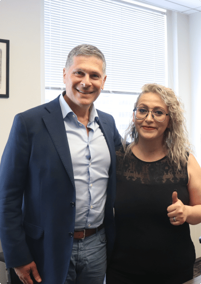 attorney Mitchell Proner posing with a happy blonde haired woman