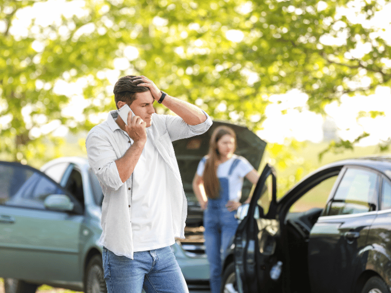 man on phone looking upset after a car accident